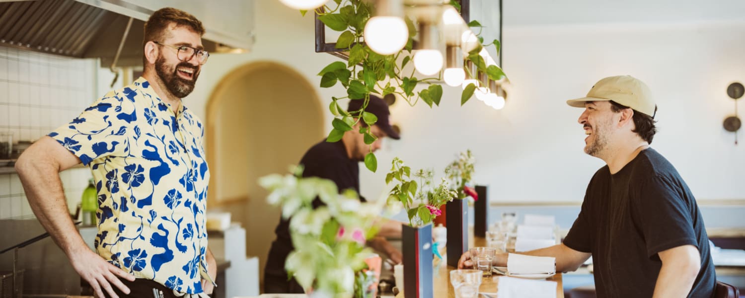 2 personnes qui discutent à un comptoir